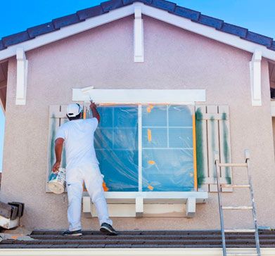 Persona pintando exterior de casa
